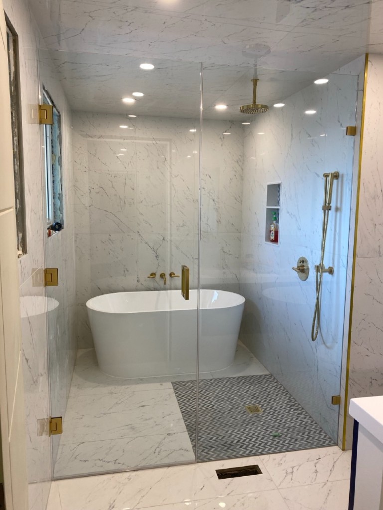 Marble wet room with freestanding tub and frameless glass screen